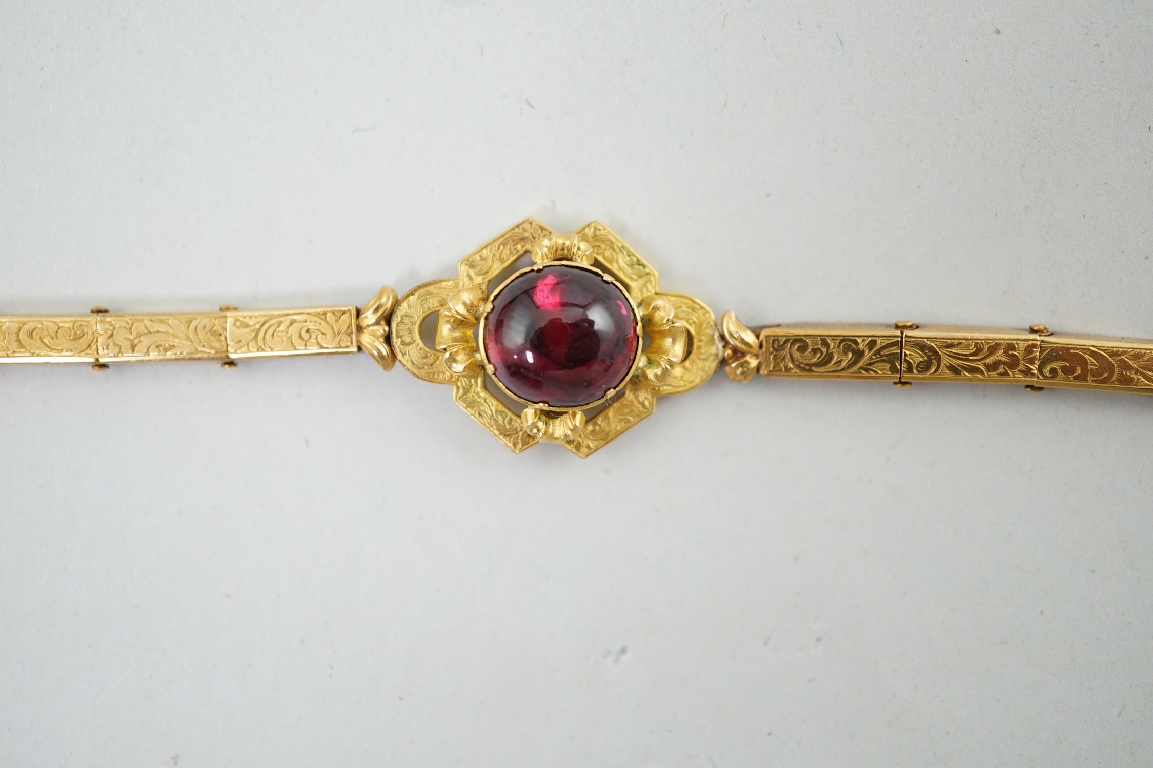 An early 19th century engraved gold and cabochon garnet set mourning bracelet